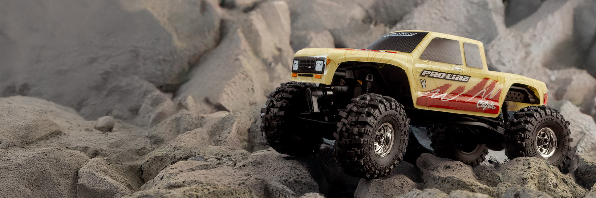 Action shot of the Pro-Line 1/30 Limited Edition Pre-Cut/Pre-Painted Coyote High Performance Tan Topo Body for the Axial SCX30 crawling over rocky terrain
